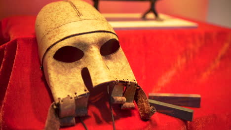 viking mask artifact on red cloth