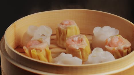 various of dim sum on wooden steamer close-up macro. steaming technique. chinese dessert food. dimsum with shrimps, fish and meat. dish in a cafe. homade. delivery
