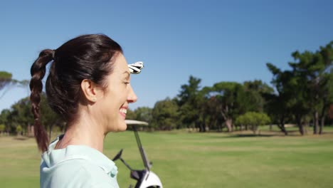 golfer shielding eyes while standing playing golf