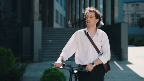young man commuting with electric scooter in urban environment