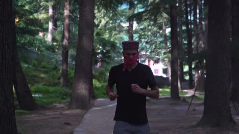 an american maintaining health by jogging with face mask on during times of corona while stuck in manali , india