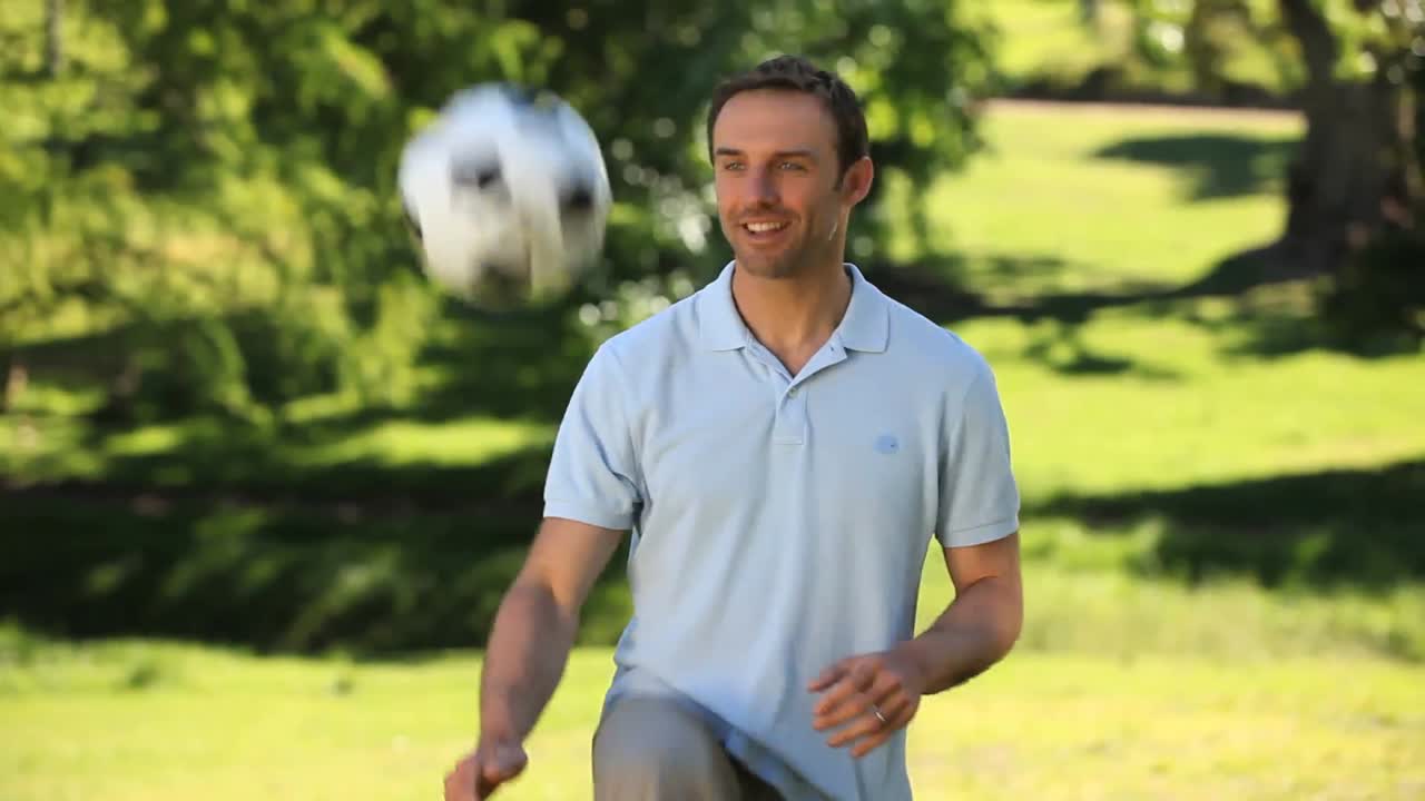 Homem fazendo embaixadinhas com uma bola de futebol