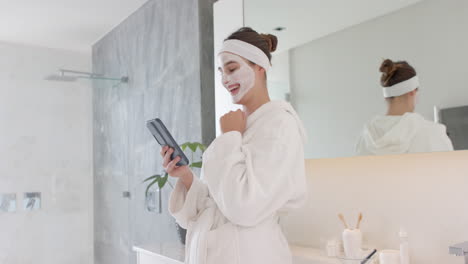 applying face mask, woman in bathrobe using smartphone in bathroom, at home