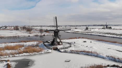 dutch windmills in snowy winter landscape, aerial view