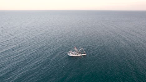 aerial shot drone shot lowering to shrimp boat while fishing in baja, mexico