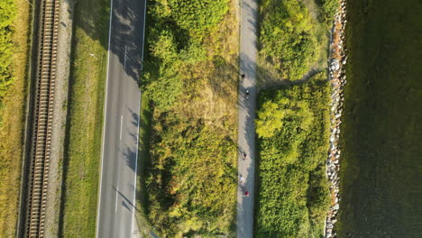 La-Vista-Aérea-De-La-Calle-Limpia-En-Kuznica,-Polonia,-Rodeada-De-Exuberantes-Plantas-Verdes-Con-Vehículos-Que-Pasan---Toma-Aérea