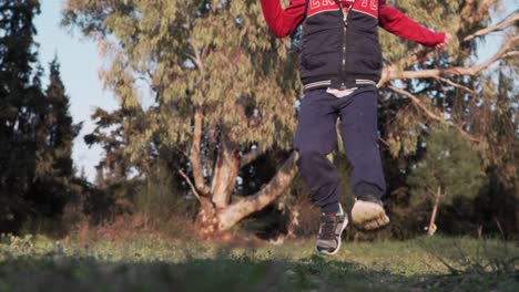 Slow motion 120fps shot of caucasian boy running towards camera and jumping