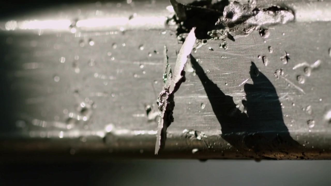 Lifting tiny blister on metal horizontal bar, sunlight warming rail, flake tearing and dangling