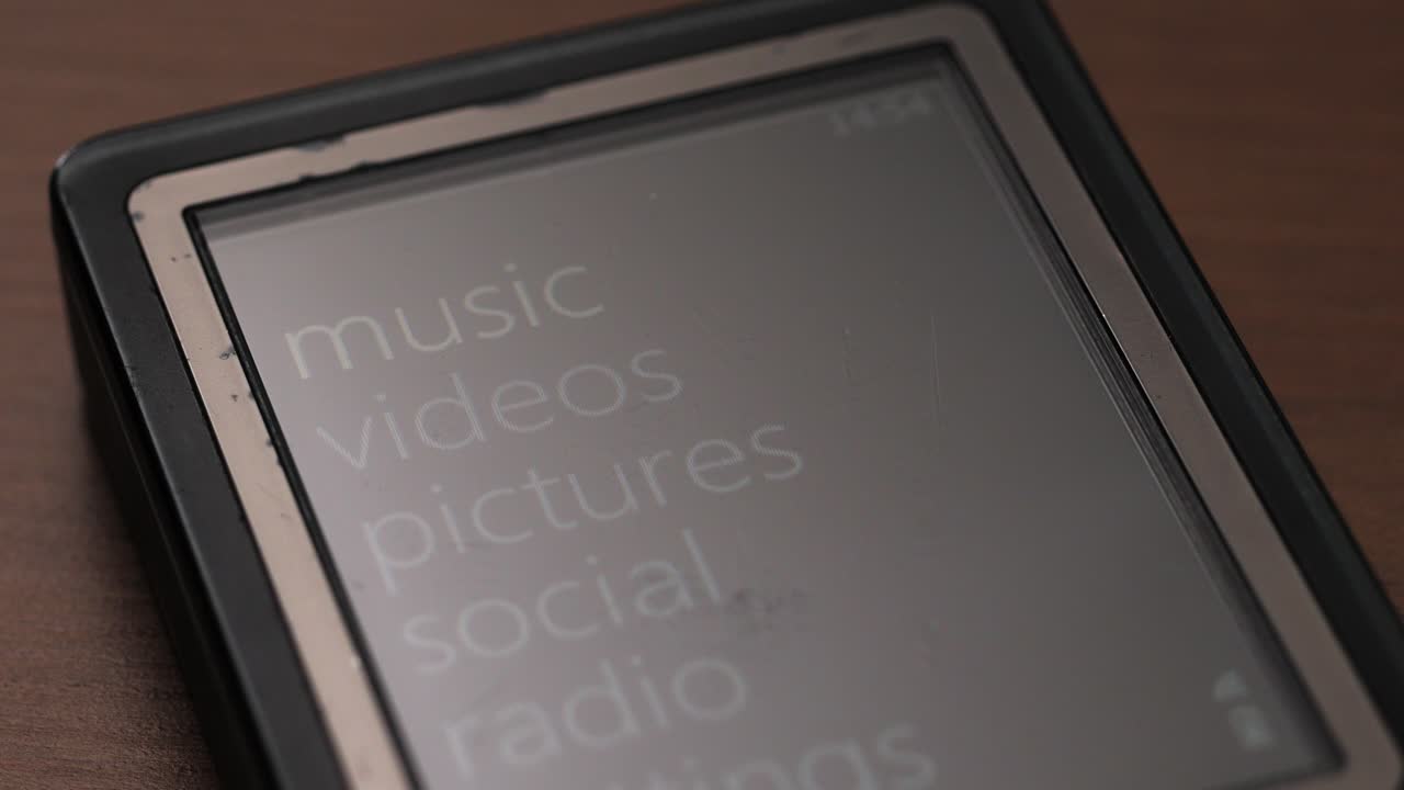 Wider view of vintage media player on table scrolling through main menu