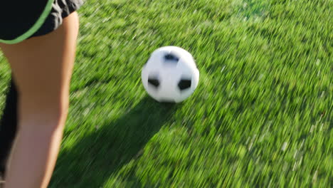 a soccer player running with a football dribbling up the grass field to score a goal and win the game