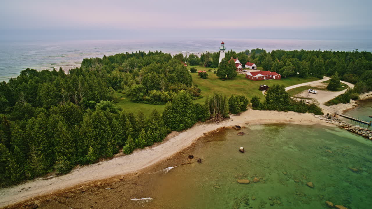 Drone shot panning lighthouse on the shore of lake Michigan