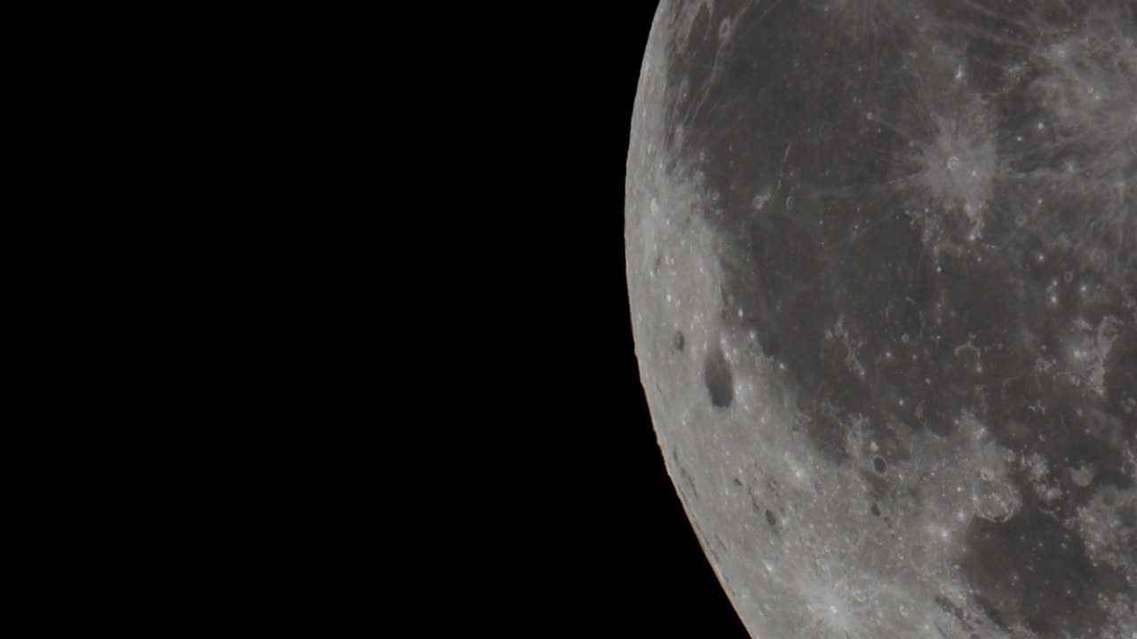 a super telephoto video of The giant full Moon passing through the night sky in space taken with a telescope