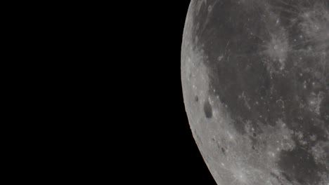 a super telephoto video of the giant full moon passing through the night sky in space taken with a telescope