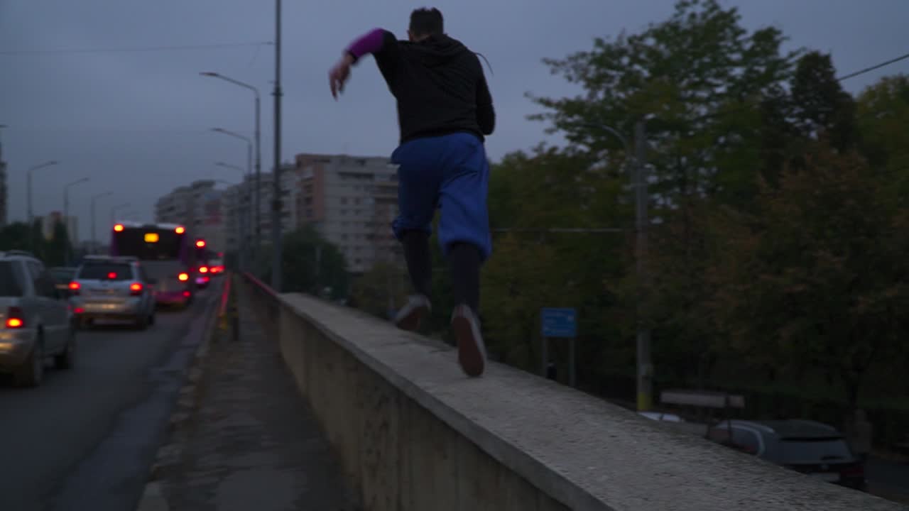 Running on the concrete barrier by the highway of Cluj, Romania - wide pan
