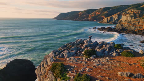 man spreading arms ocean coast aerial view. male person watching marine nature
