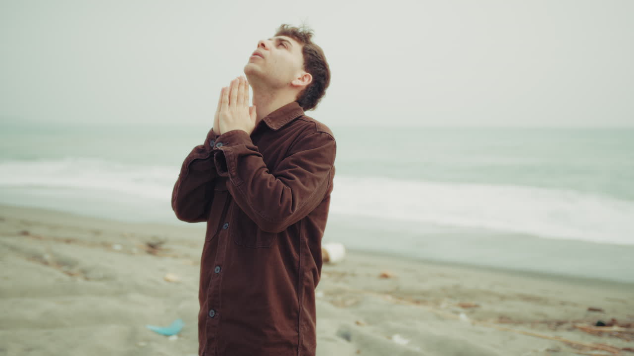 Momento intenso di preghiera religiosa per un uomo in spiaggia