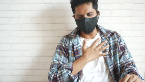 man coughing and wearing a mask