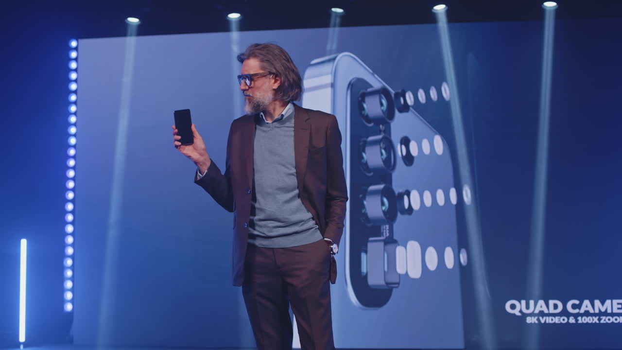 기술 컨퍼런스에서 스마트폰을 선보이는 남자