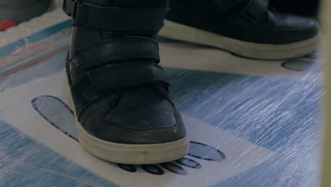 Close-up-view-of-boy-feet-in-black-sneakers