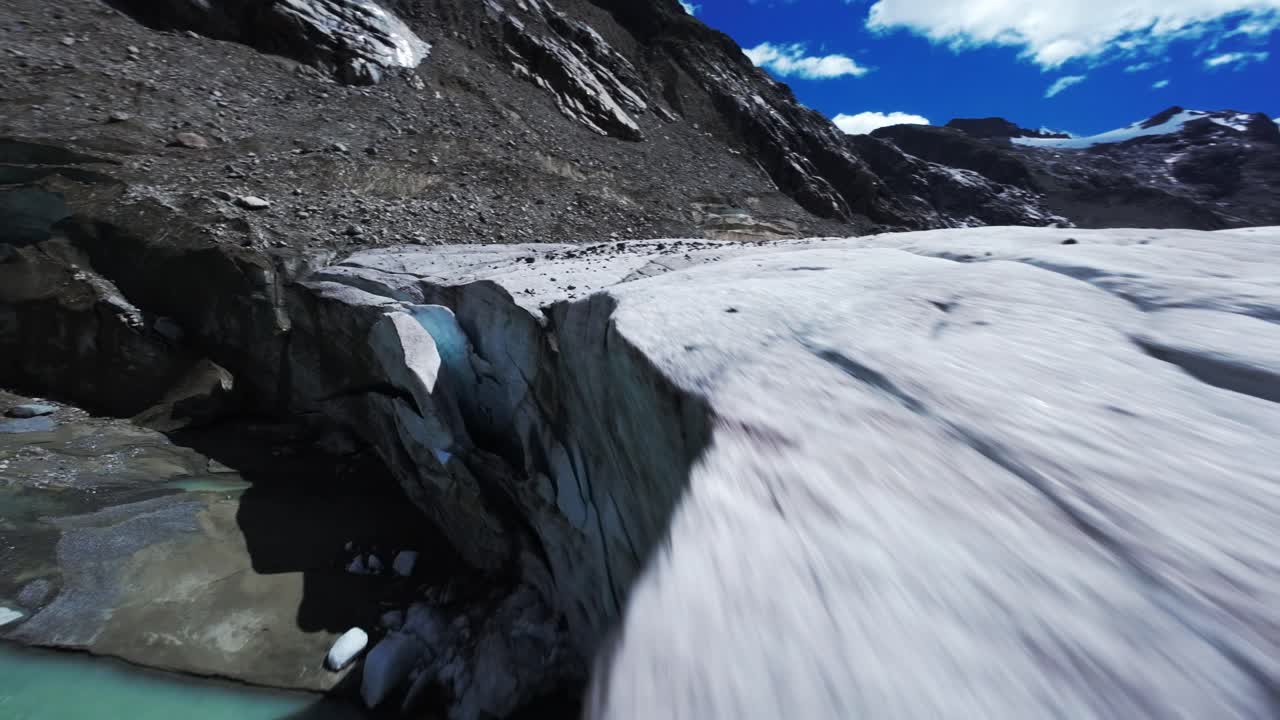 FPV drone glides over stunning Swiss glacier on a clear day