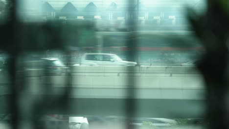 Buses,-trucks-and-cars-passing-over-the-flyover,-view-from-the-apartment-window-curtains