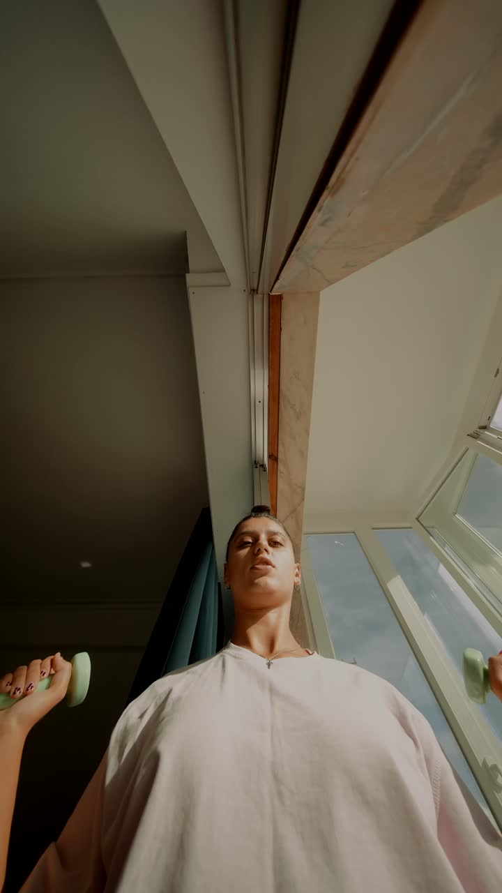 Woman exercising with dumbbells indoors