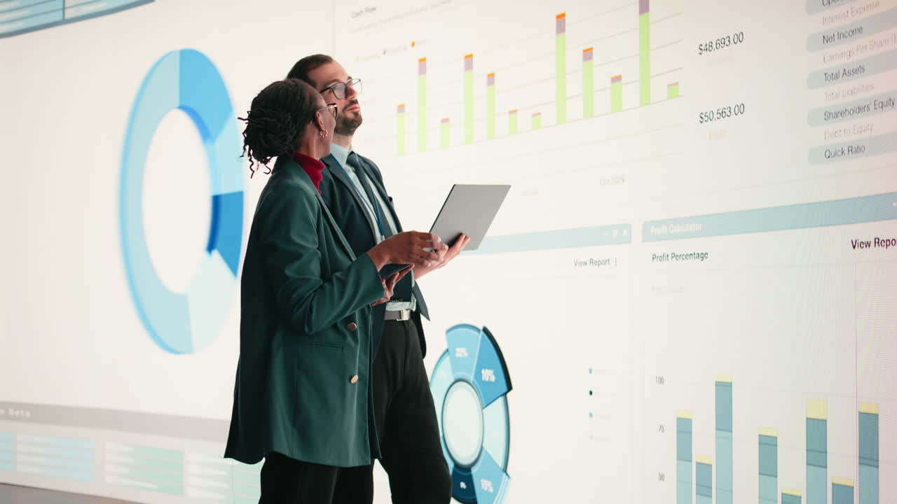 Forretningsfolk analyserer finansdata på stor digital skjerm