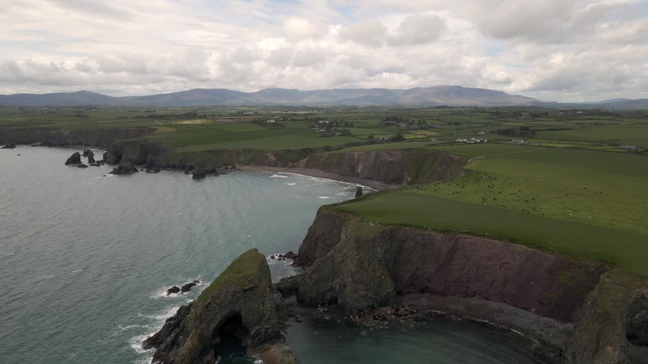 toma de drones que muestra un gran paisaje en irlanda con una playa y acantilados marinos