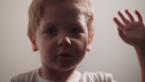 un niño cansado se limpia el sudor de la cara con la mano mirando a la cámara