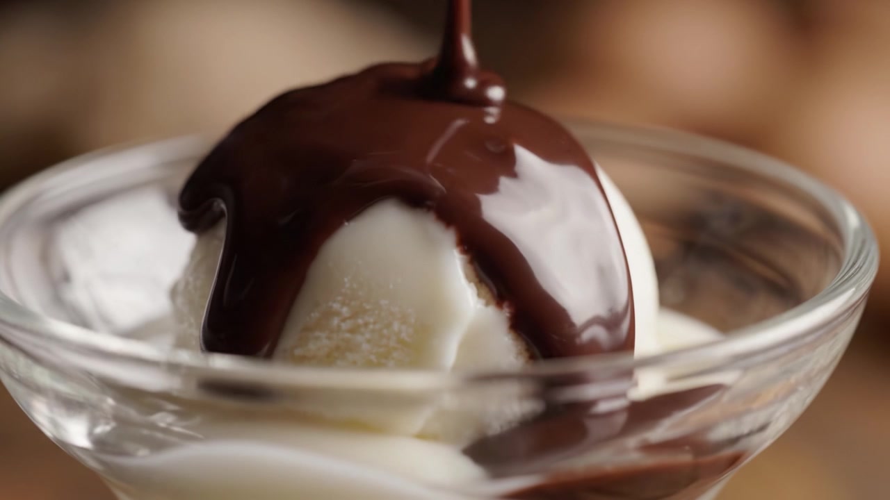 Squisita Delizia di Gelato: Una Tentatrice Trasformazione dalla Semplice Vaniglia allo Splendore di un Ricco Dessert al Cioccolato in una Ciotola di Vetro Trasparente