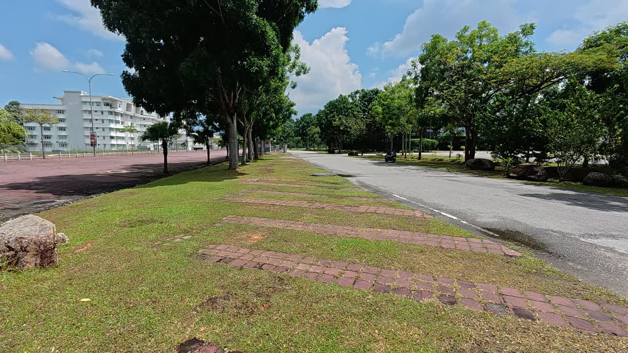 A car park features eco-friendly grass paver blocks. These porous concrete blocks allow grass to grow through the surface voids. This design promotes green infrastructure and sustainable paving