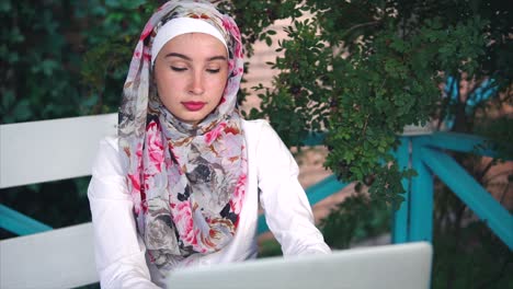 woman working on laptop outdoors in a hijab