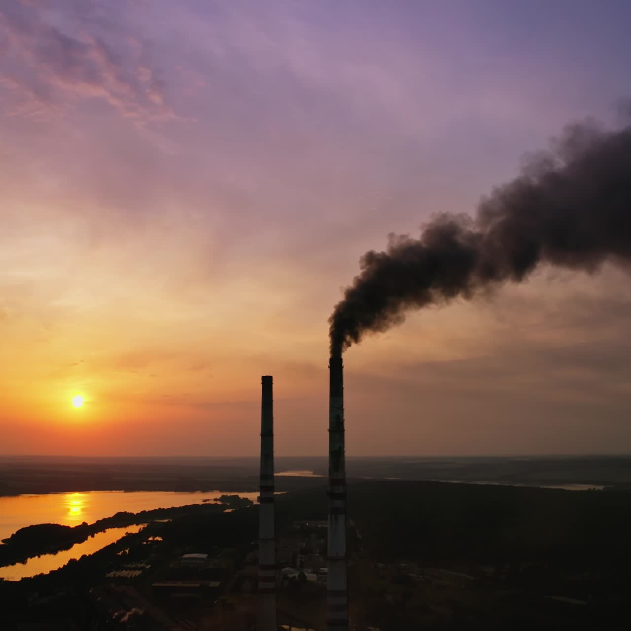 Air pollution smog from factory. Aerial drone view of factory during sunset