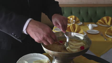 küchenchef bereitet crepe suzette vor