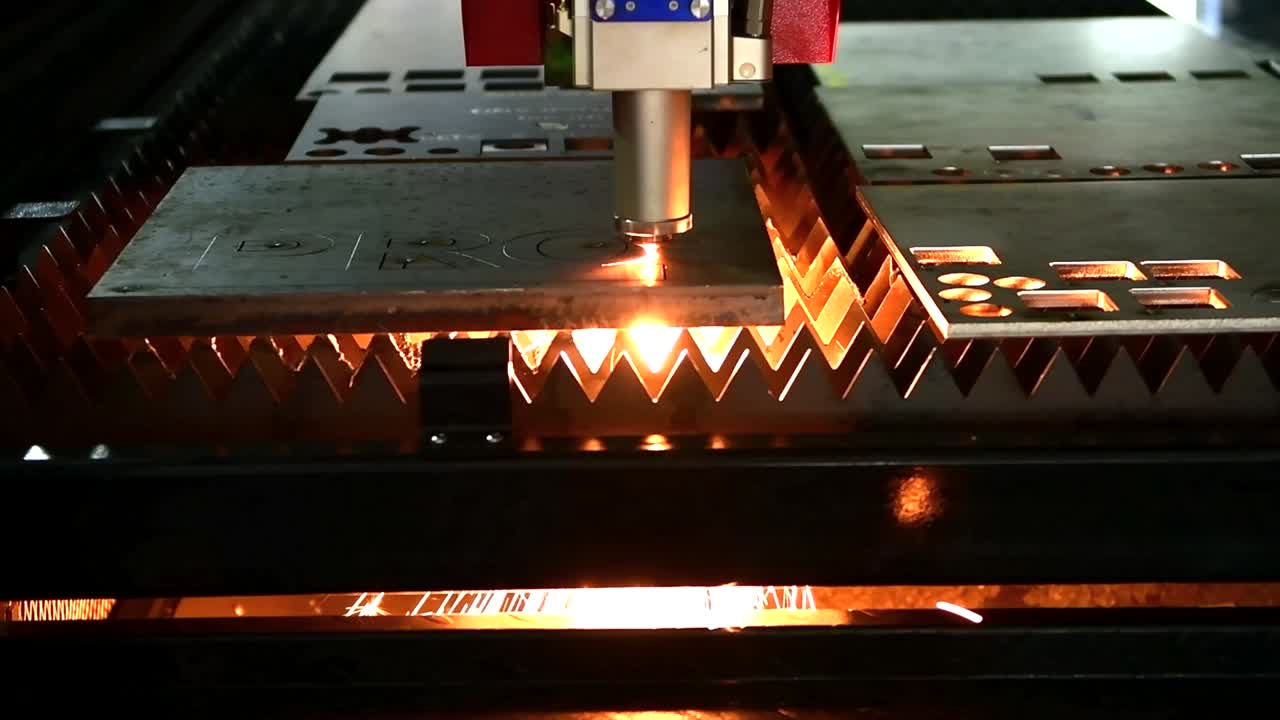 Industrial laser cut machine while cutting the sheet metal with the sparking light.