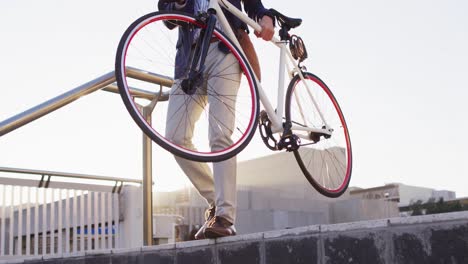 asian man carrying bicycle while walking down the stairs at corporate park