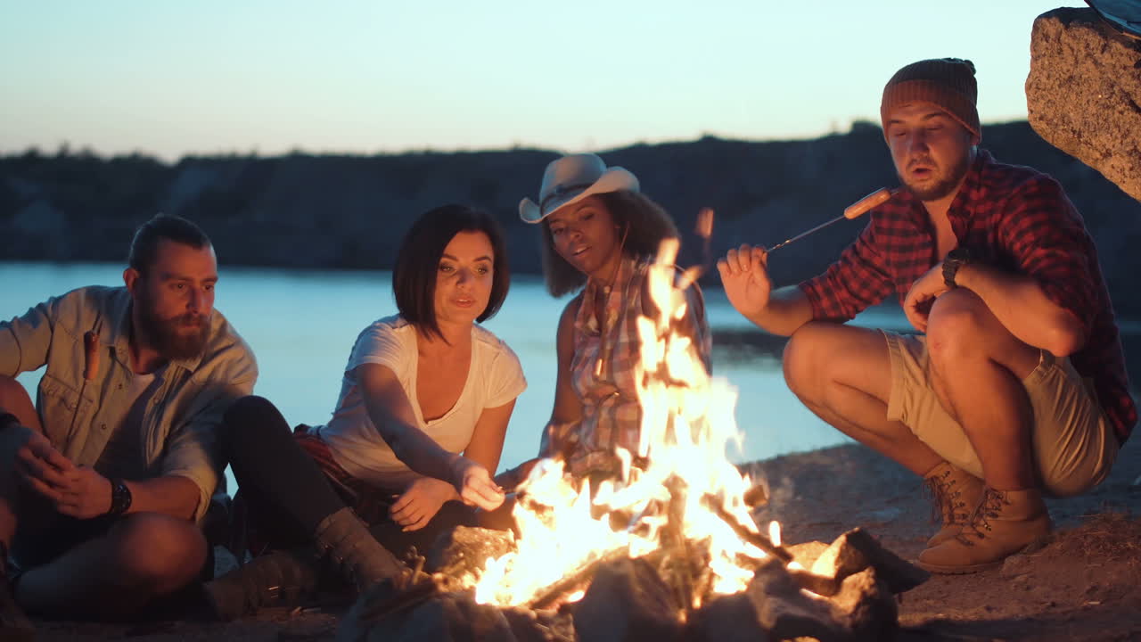 Friends Gather Around a Campfire by the Lake