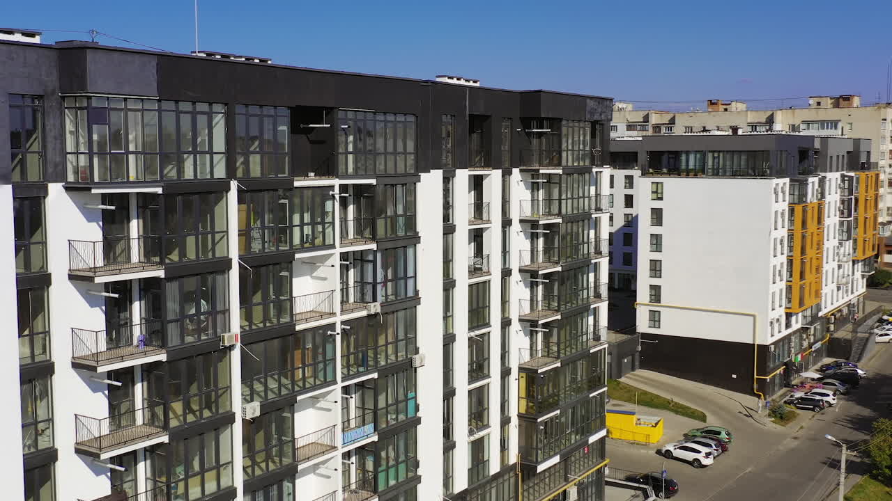 Newly built urban architecture. Exterior of residential building in the city. Modern building with tall glass windows and balconies.