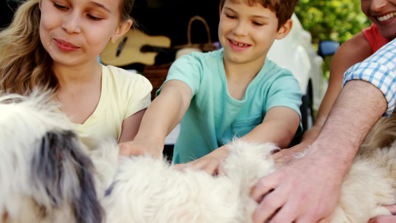 공원에서 개와 함께 앉아 있는 가족