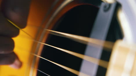 guitarist plays on metal bass string of acoustic guitar