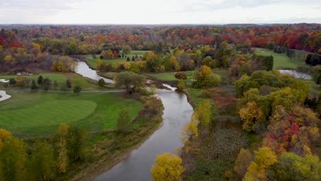 fly over a river in a park in a fall, cloudy, moody day