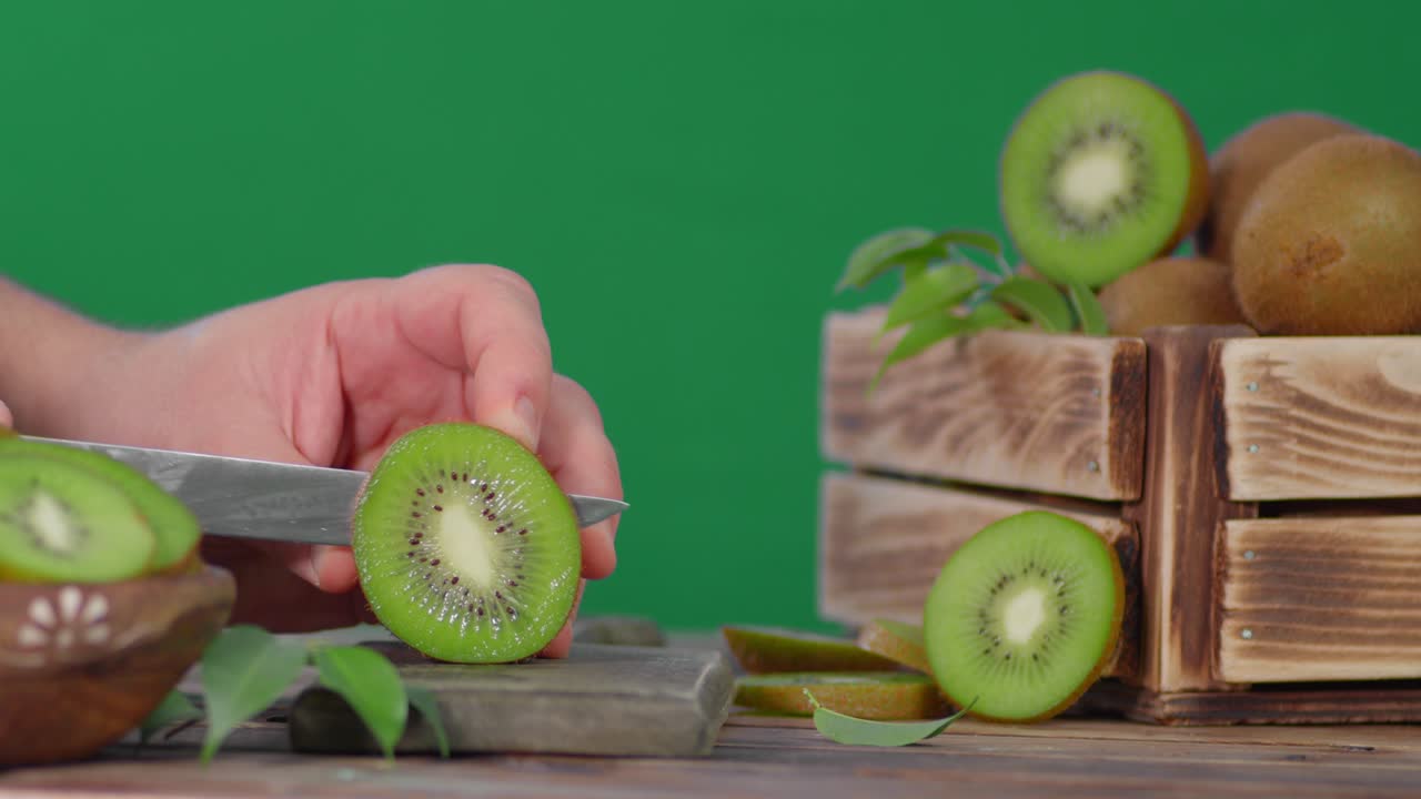 o homem corta um kiwi fresco, uma colheita fresca de kiwi.