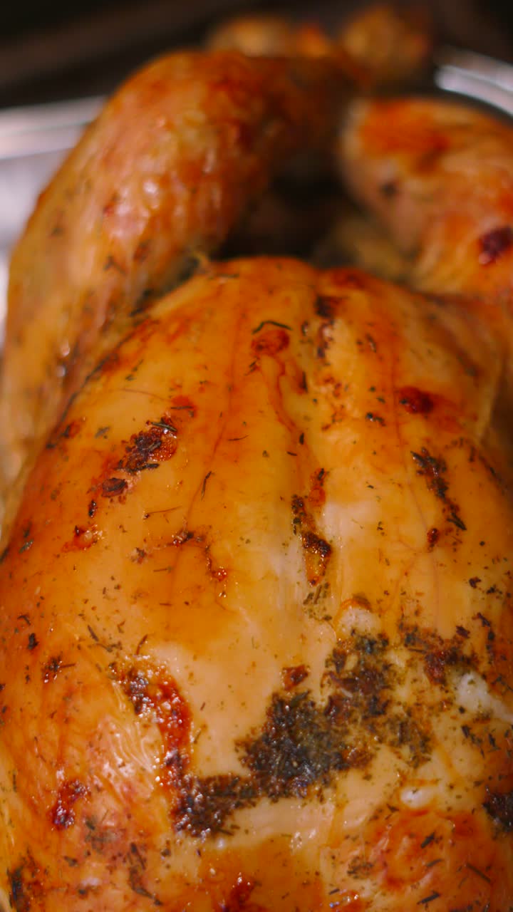 Vertical Video Moving Down Whole British Cooked Roast Chicken with Garlic Herb Seasoning in Tray. Poultry Ready to Carve and Serve to Family and Guests.
