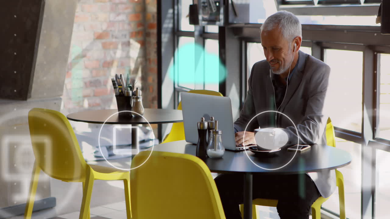 Animation of icons and data processing over caucasian businessman using laptop