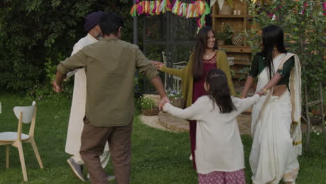 joyful indian family dancing in a garden celebration