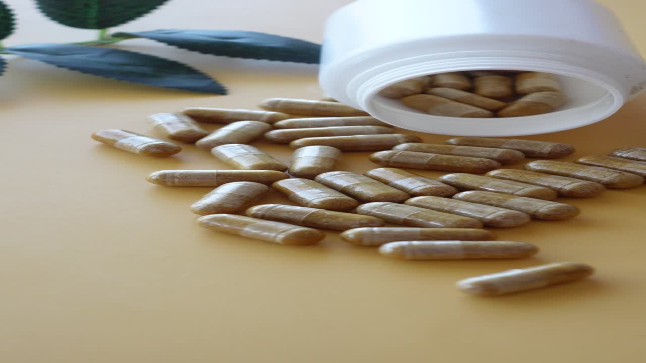 pastillas marrones derramadas de una botella blanca