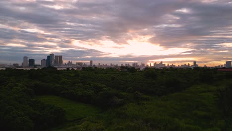 phnom penh city skyline buildings and green forest with sunset view, drone shot