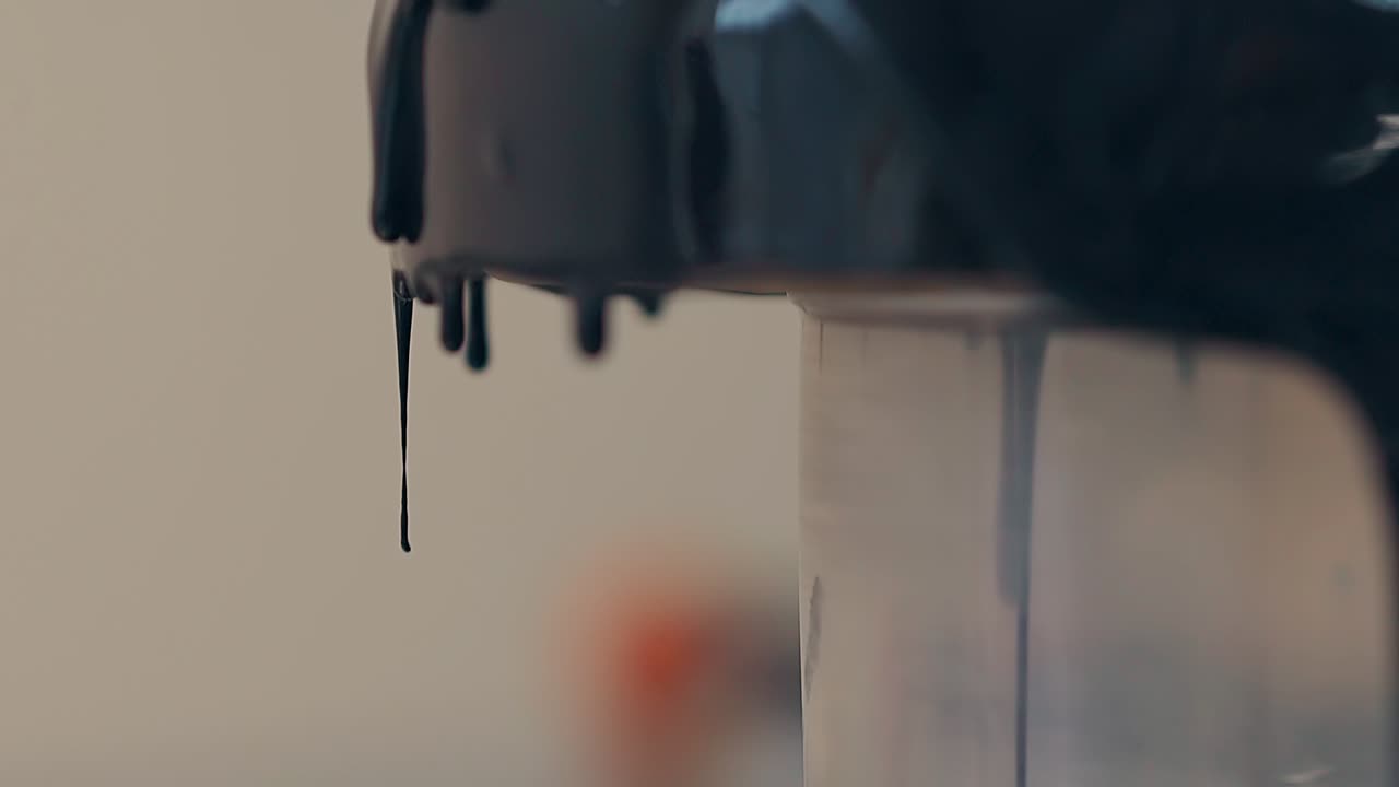 el chocolate negro fluye lentamente hacia abajo con gotas de rosquilla