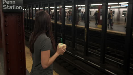 Junge-Attraktive-Frau-Wartet-Darauf,-Dass-Die-U-bahn-Mit-Kaffee-In-Der-Hand-An-Einer-New-Yorker-U-bahnstation-Ankommt