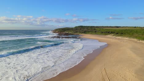 foamy waves splashing on rocky coastline of malabar headland national park near maroubra beach in australia